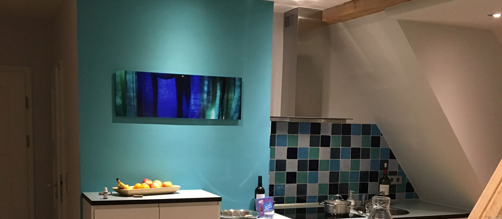 Küche mit türkis gestrichener Wand und Mosaikfliesen