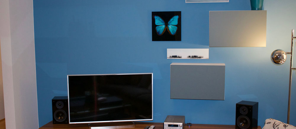 Wohnzimmerwand in Hellblau mit Wandregalen und Fernseher