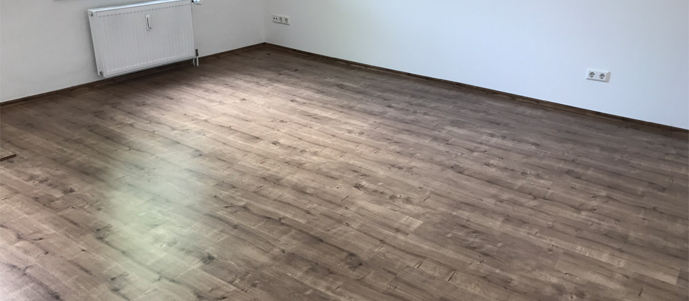 Frisch verlegter Laminatboden in Holzoptik in einem leeren Zimmer