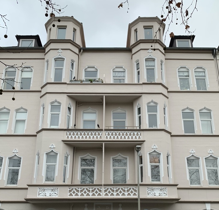 Frisch sanierte Altbaufassade mit Stuck und Balkonen